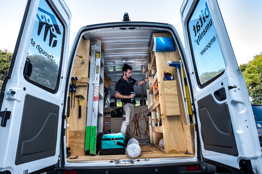 A staff of Habitat for Humanity, a non-government organization, prepares for work in his van. The Habitat for Humanity provides home repair services to the low income families as a preventative measure for rheumatic fever in Auckland.