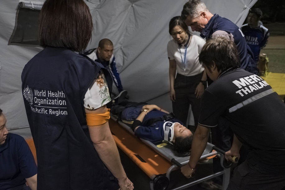 WHO representatives with students of a local medical university conducting a simulation of medical evacuation and hospitalization of patients to an emergency tent at the Ministry of Health compound in Bangkok, Thailand.