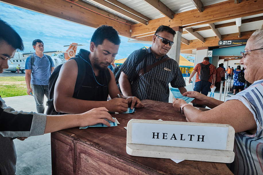 A health inspector checks the arriving passengers in Tuvalu airport.