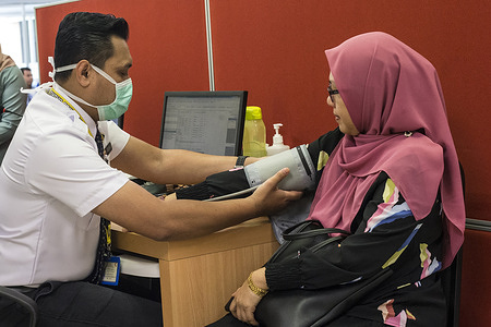 An assistant medical officer measures blood pressure at Klinik Kesihatan Presint 18 Putrajaya