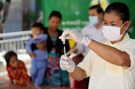 Sin Sambo, a nurse at Chhoeng Health Center, is preparing the vaccine for the immunization outreach program at Tapich Village, Chhoeng Commune Ponhea Leu District in Kandal Province. Disclaimer: This image was captured during the global response to the COVID-19 pandemic. The contents of this image reflect the guidance communicated by local public health authorities at the time of its capture. Please note, public health guidance differs among countries and is indicative of the local context.