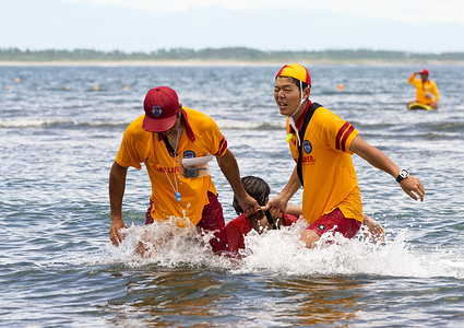 Lifesavers rescues a drowning swimmer by a lifeguard tube during a mockup lifesaving practice at Aoshima Beach in Miyazaki, Miyazaki Prefecture, south western Japan.  Japan Lifesaving Association has worked for drowning prevention program to educate new licensed lifesavers and conduct the junior programs for water safety as well as using and developing new technology to assist lifesaving activities.