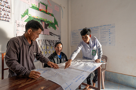 (From left) BanBor Deputy Village Chief Bouava Lor, Village Chief Mailor Xong and Community Hospital Director Dr Lae Manivong goes through the community map which identifies the different communities in need and action plans.  BanBor Village is part of CONNECT (Community Network Engagement for Essential Healthcare and COVID-19 Responses through Trust), an initiative created by a coalition of government partners, with the support of WHO, to empower local ownership of health through a sequence of participatory workshops which target different levels of governance beyond the health sector. The Ministry of Health and Ministry of Home Affairs-led initiative is empowering local communities to enhance trust, ownership and leadership regarding health particularly for rural and marginalized groups. Note: Title reflects the respective position of the subject at the time the photo was taken. Disclaimer: This image was captured during the global response to the COVID-19 pandemic. While the contents of this image might not be directly related to COVID, processes reflect the guidance communicated by local public health authorities at the time of its capture. Please note, public health guidance differs among countries and is indicative of the local context.