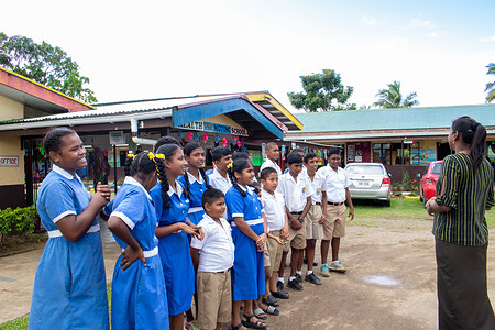 Teacher Shabina Prakesh (right) talks to students at the Krishna Vedic School in Nausori, Fiji. Krishna Vedic School is one of the 285 Health Promoting Schools across Fiji. The Health Promoting Schools programme, jointly led by the Ministry of Health and Medical Services and the Ministry of Education, Heritage and Arts, aims to integrate health and education by providing a supportive environment for children that fosters healthy habits, prevents noncommunicable diseases, improves academic performance, and reduces health risks over the life course.   Related: https://www.who.int/health-topics/health-promoting-schools#tab=tab_1