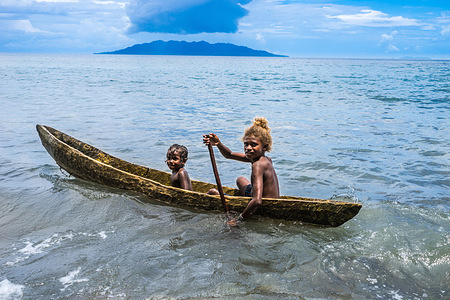Children in a small barque in the sea