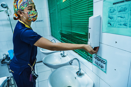 A health worker washes her hands before delivering a baby.